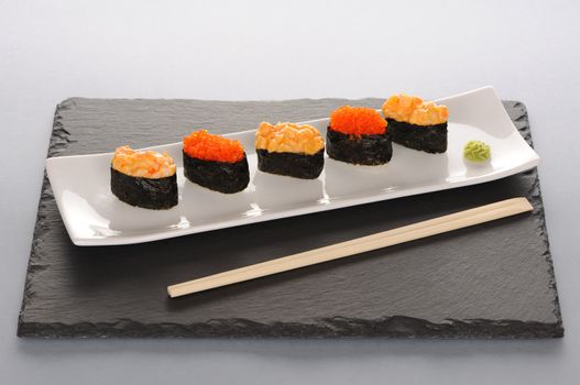 Tobiko and spice sushi on a slate plate