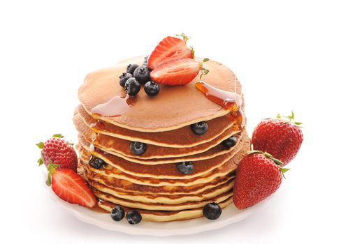 Delicious freshly prepared pancakes with strawberry and blueberries isolated on white