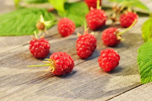 Raspberry with leafs on wooden table