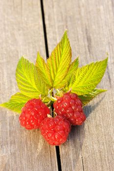 Raspberry with leafs on wooden table