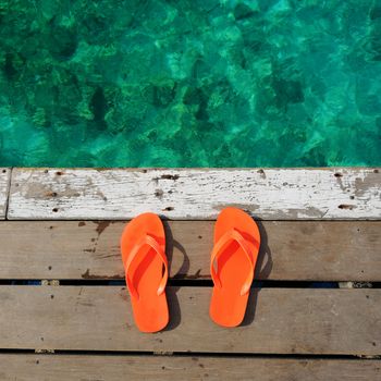 Sandals at jetty by the sea