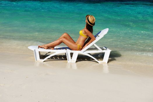 Girl on a tropical beach with hat