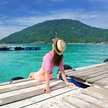 Woman at beach jetty wearing hat