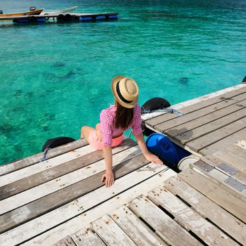 Woman at beach jetty wearing hat