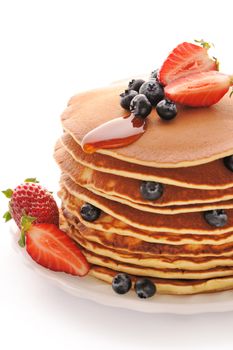 Delicious freshly prepared pancakes with strawberry and blueberries isolated on white