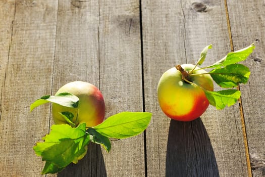 Fresh apples with leaves on wooden table