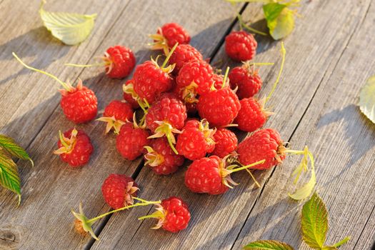 Raspberry with leafs on wooden table