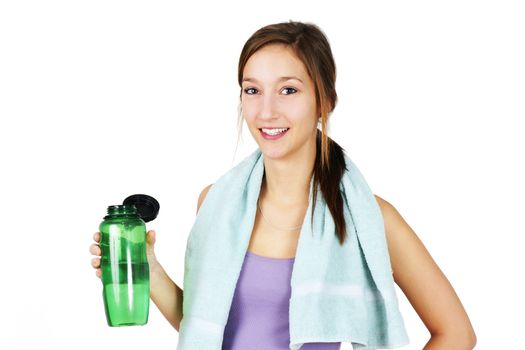 Cute, healthy and sporty young woman with towell on shoulders drinking water after working out, yoga or other exercise.