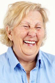 Portrait of a blond senior woman laughing hysterically or giggling.