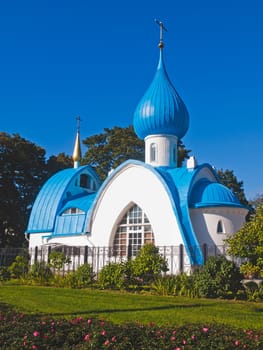 Orthodox white church with blue domes in the park area