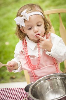 Happy Adorable Little Girl Playing Chef Cooking in Her Pink Outfit.