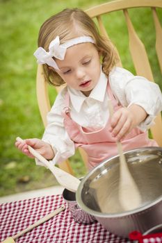 Happy Adorable Little Girl Playing Chef Cooking in Her Pink Outfit.