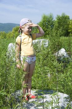 little girl playing on the river bank