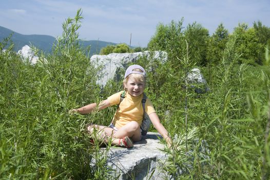 little girl playing on the river bank