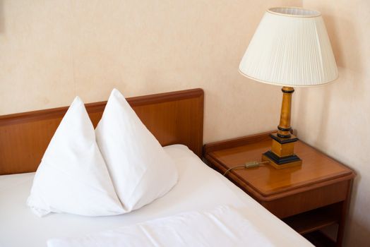 a hotel room with beds, lamps and pillows