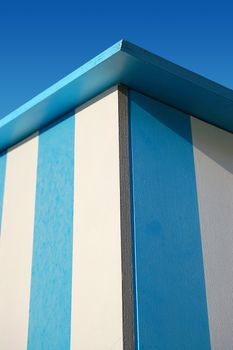 Detail of beach hut blue and white on a blue sky
