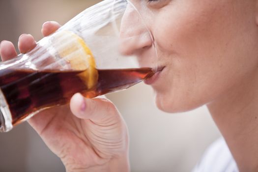 young woman is drinking lemonade outside in summer close up