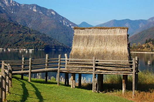 Photo of ancient hut on wharf in lake shore alpine and green lawn