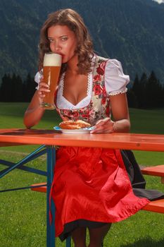 Bavarian girl in costume enjoys a wheat beer
