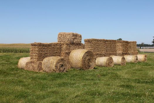 a tractor in a field of straw bales