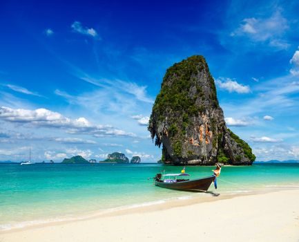 Long tail boat on tropical beach with limestone rock, Krabi, Thailand