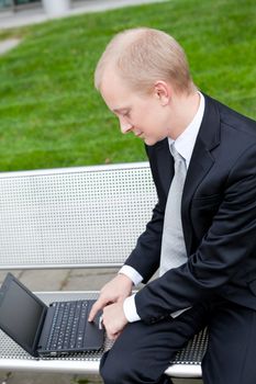 business man sitting outdoor working with notebook in summer