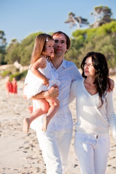 happy young family with daughter on beach in summer lifestyle