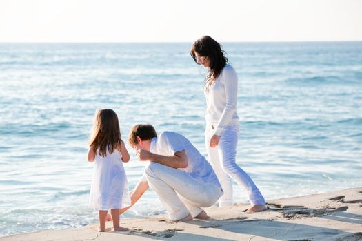 happy young family with daughter on beach in summer lifestyle