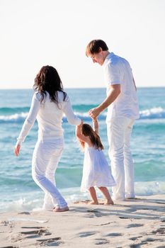 happy young family with daughter on beach in summer lifestyle