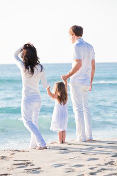 happy young family with daughter on beach in summer lifestyle