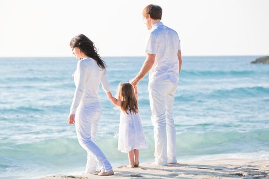 happy young family with daughter on beach in summer lifestyle