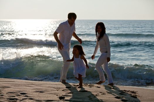 happy young family with daughter on beach in summer lifestyle