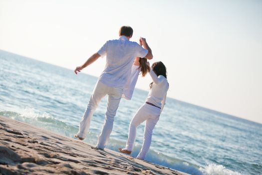 happy young family with daughter on beach in summer lifestyle