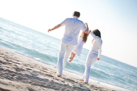 happy young family with daughter on beach in summer lifestyle