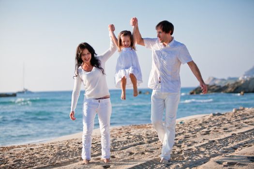 happy young family with daughter on beach in summer lifestyle