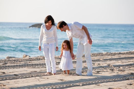 happy young family with daughter on beach in summer lifestyle