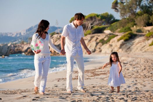 happy young family with daughter on beach in summer lifestyle