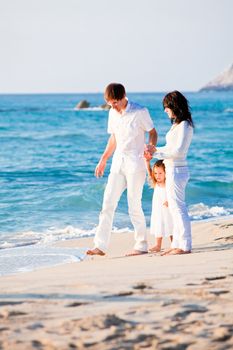 happy young family with daughter on beach in summer lifestyle