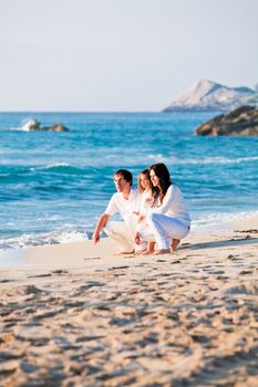 happy young family with daughter on beach in summer lifestyle