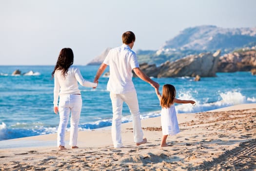 happy young family with daughter on beach in summer lifestyle