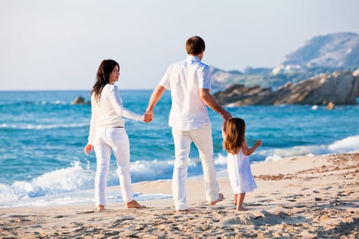 happy young family with daughter on beach in summer lifestyle