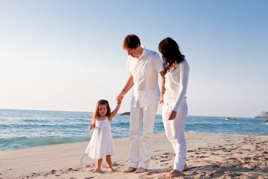 happy young family with daughter on beach in summer lifestyle