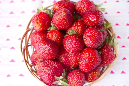 Fresh strawberries in a basket on a round table