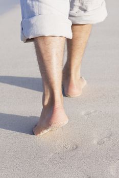 walking barefoot in the sand in summer holidays on beach