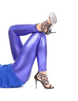 Cropped view image of a woman's sexy legs clad in shimmering blue leggins and stilettos