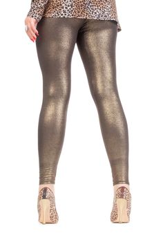 Cropped view image of a woman's sexy legs clad in shimmering golden leggins and stilettos