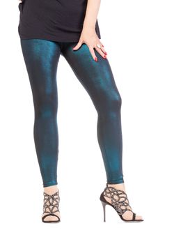 Cropped view image of a woman's sexy legs clad in shimmering green leggins and stilettos