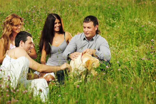 friends and dog in green grass field