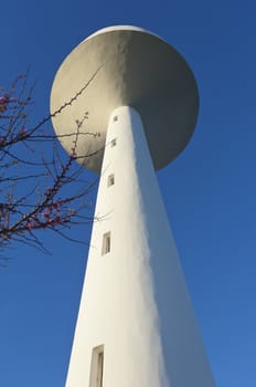 White painted water tower against a clear blue sky in the small village of S. Bartolomeu do Outeiro,  Alentejo, Portugal