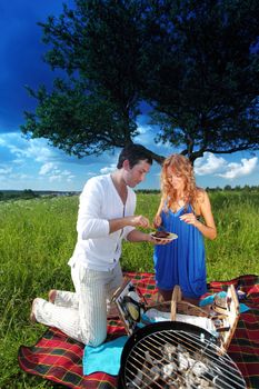 man and woman on picnic in green grass